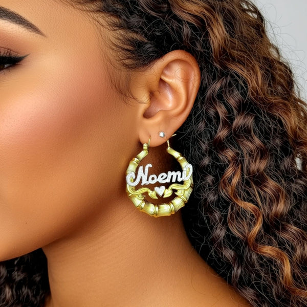 Close-up of a person wearing a gold hoop earring with 'Noemi' inscribed.